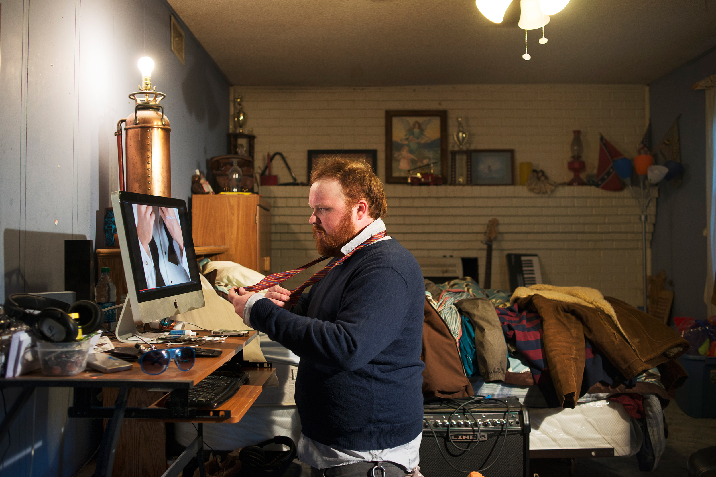 <strong>20% of all millennials live with their parents, and 60% of all young adults receive monetary support from them, reports the <a href="http://www.nytimes.com/2014/06/22/magazine/its-official-the-boomerang-kids-wont-leave.html?_r=0" title="New York Times Magazine" target="_blank">New York Times Magazine</a>. Only one in ten young adults from the previous generation moved back under the same roof and needed a financial lifeline from Mom and Dad.</strong>
Title: "Mikey Billings, 29, Statesville NC," from the series <em><a href="http://damoncasarez.com/albums/boomerang-kids/" title="Boomerang Kids" target="_blank">Boomerang Kids.</a></em>
<a href="http://www.damoncasarez.com" title="Damon Casarez" target="_blank">Damon Casarez</a>'s project, <a href="http://damoncasarez.com/albums/boomerang-kids/" title="Boomerang Kids" target="_blank">Boomerang Kids</a>," is a series of portraits of young adults who've had to move back home with their parents after college for financial reasons, or who have never been able to leave home. High student loan payments, a competitive job market, and graduating into a recovering economy are a large reason why there is a trend to stay home longer. <a href="http://www.nytimes.com/2014/06/22/magazine/its-official-the-boomerang-kids-wont-leave.html?_r=0" title="New York Times Magazine" target="_blank">The series was commissioned by the <em>New York Times Magazine</em></a> and was photographed in 8 states and 14 cities across the U.S.