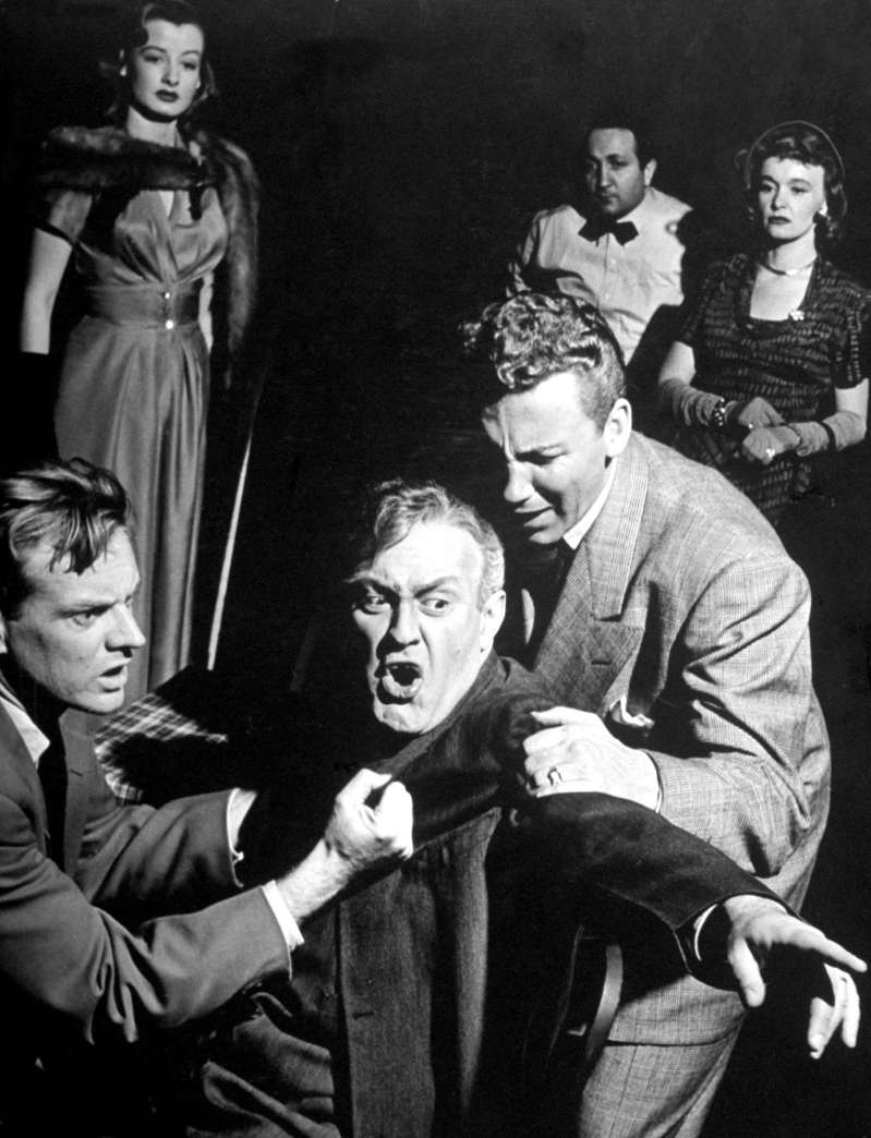 Caption from LIFE. Losing his mind as result of worry, the salesman, Willy Loman (Lee J. Cobb), babbles at imaginary characters in a restaurant. This two sons attempt to restrain him while a couple of floozies the boys have picked up look on in cold puzzlement.