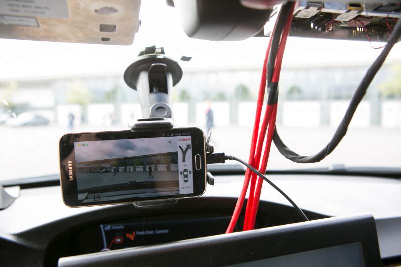 A Samsung Electronics Co. smartphone camera displays a wrong-way driver warning app as it sits on the windshield of a Bayerische Motoren Werke AG (BMW) 3 Series automobile at the Robert Bosch GmbH driverless technology press event in Boxberg, Germany, on Tuesday, May 19, 2015.