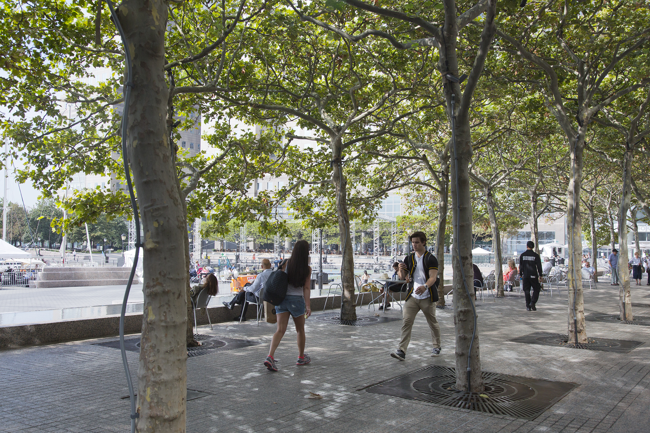 People enjoy a sunny day on Waterfront Plaza adjacent to Brookfield Place, New York.