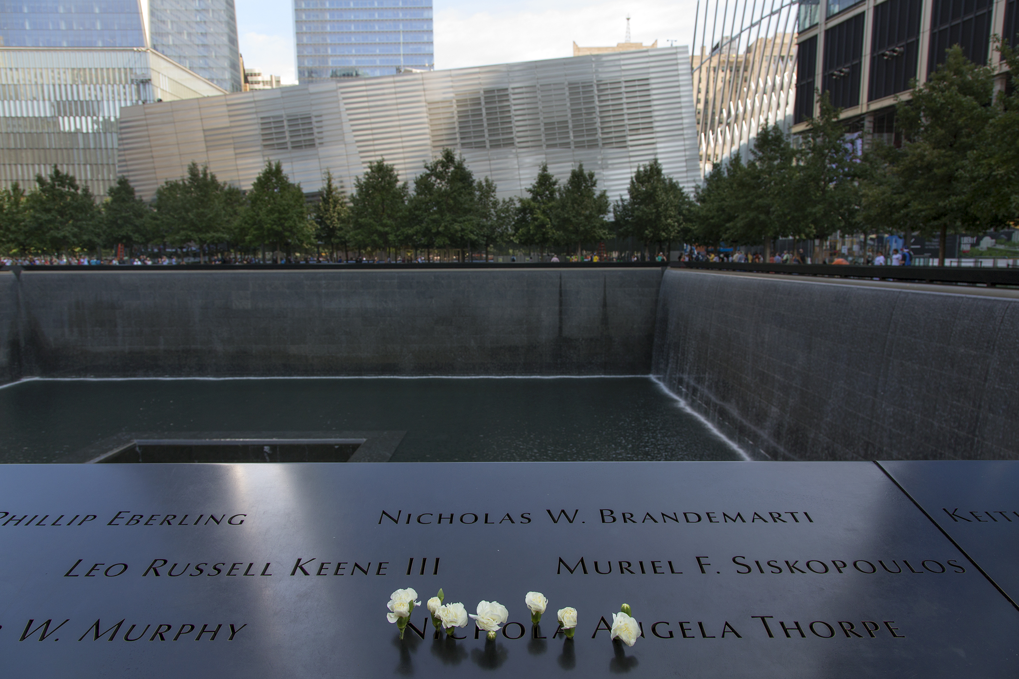 The names of victims of the September 11 terrorist attacks are engraved into the rim of one of the twin black granite reflecting pools at the September 11 Memorial and Museum, New York.