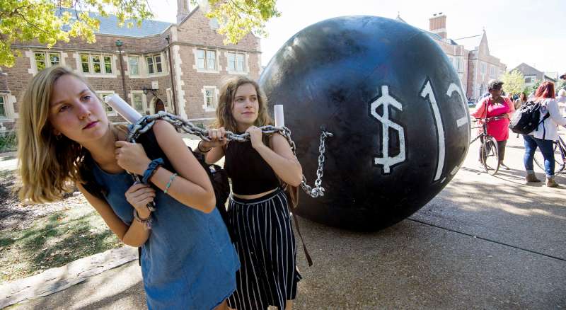 Students pull a mock ball & chain representing the $1.4 trilling outstanding student debt at Washington University in St. Louis, Missouri, where second presidential debate will be held between Republican nominee Donald Trump and his Democratic counterpart Hillary Clinton.