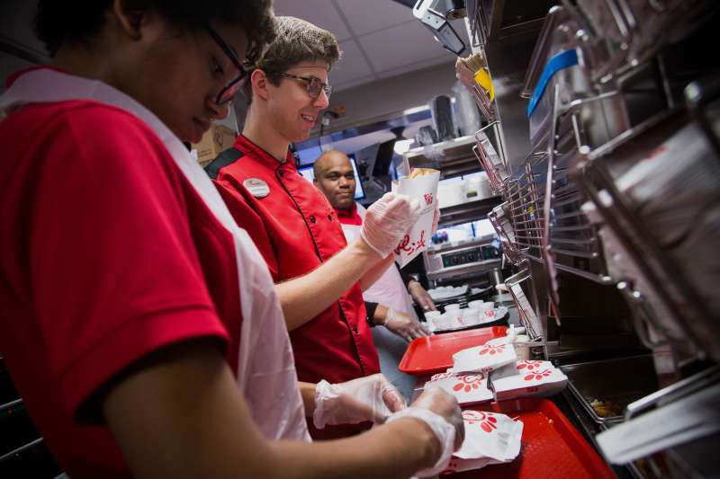 Employees prepare fried chicken sandwiches for guests during an event ahead of the grand opening for a Chick-fil-A restaurant in New York, U.S., on Friday, Oct. 2, 2015. Chick-fil-A, the Southern chicken-sandwich chain that has drawn both controversy and copycats over the years, has finally arrived in New York. The company will open a 5,000-square-foot (465-square-meter), three-level restaurant in Manhattan's Garment District that will be the chain's largest location in the nation. Photographer: Michael Nagle/Bloomberg via Getty Images