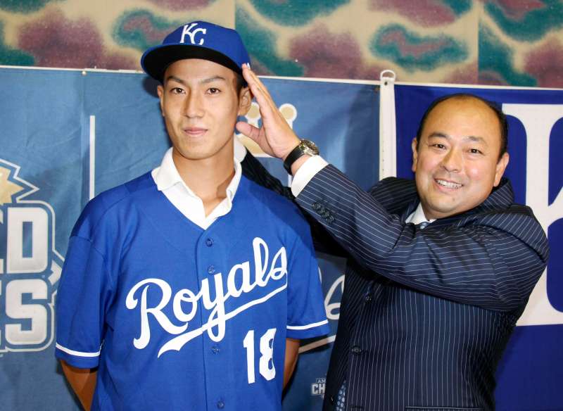 In this July 8, 2018, photo, Kaito Yuki, left, poses with Hiroyuki Oya, a Royals international scout, for photographers at a press conference in Osaka, western Japan. Yuki is headed to the Kansas City Royals organization instead of attending high school in Japan. The team signed Yuki, a 16-year-old pitcher, out of junior high to a standard seven-year minor league contract Sunday. He is thought to be the first Japanese junior high school player to sign with a major league club.