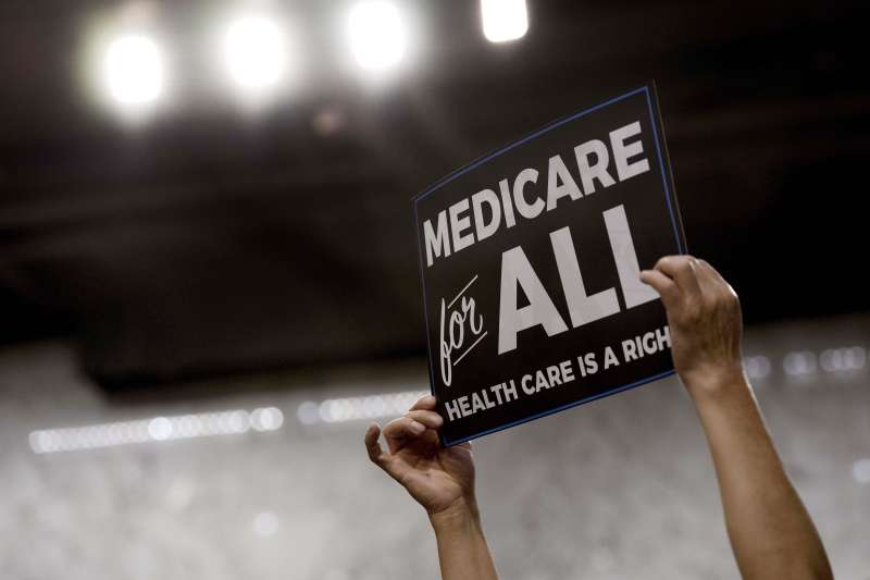 A member of the audience holds up a placard as US Senator Bernie Sanders, Independent from Vermont, discusses Medicare for All legislation on Capitol Hill in Washington, DC, on September 13, 2017.
The former US presidential hopeful introduced a plan for government-sponsored universal health care, a notion long shunned in America that has newly gained traction among rising-star Democrats. / AFP PHOTO / JIM WATSON (Photo credit should read JIM WATSON/AFP/Getty Images)