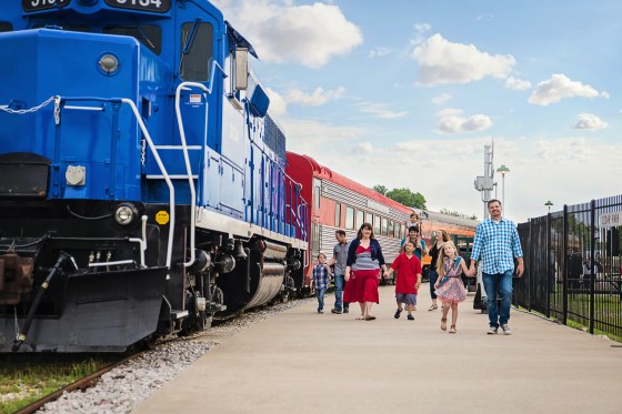 A family walks next to the Austin Steam Train in Cedar Park Texas