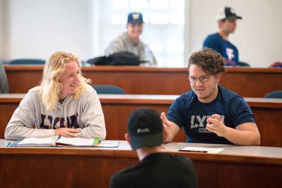 Students talking amongst themselves in a classroom at Lyon College