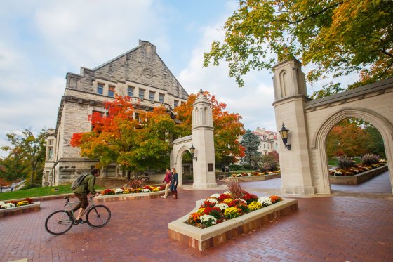 A students rides a bike through the Indiana University Bloomington campus