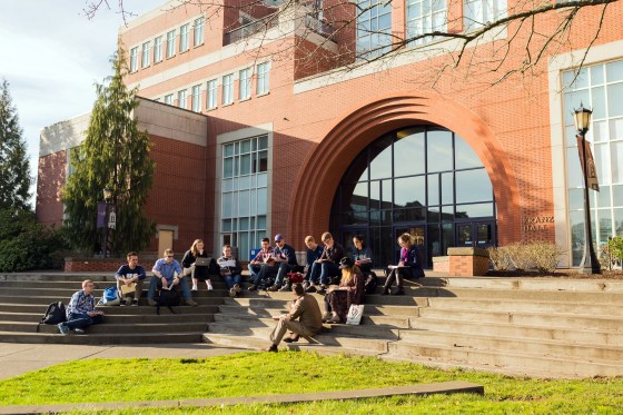 Students sit outside campus on the University of Portland