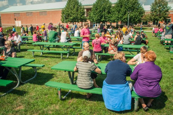 People sitting on picnic tables and conversing at Clarkson University